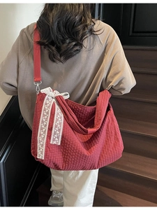 Red checkered tote bag with white lace bow and wide shoulder strap shown on a model
