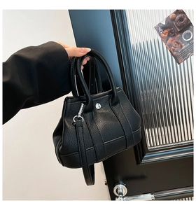 Detail of black lychee grain leather bucket bag with silver hardware and top handle