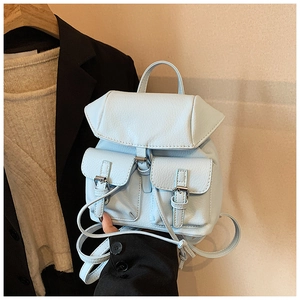 Detail view of light blue lychee pattern leather backpack with metal buckles and straps