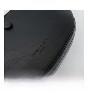 Close-up of black lychee grain leather texture with debossed fashion brand logo