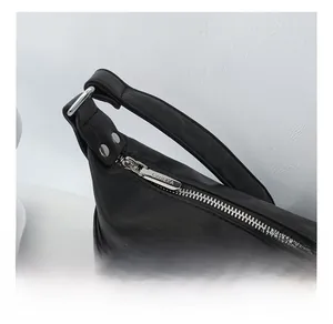 Close-up of the smooth zipper and silver metal hardware on this black leather bag