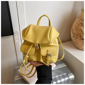 Detail view of bright yellow pebble leather mini backpack with silver buckle accents