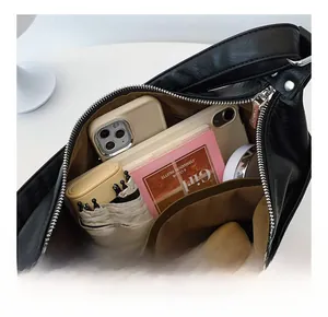 Detail showing the large interior capacity and storage compartments of the black leather bag