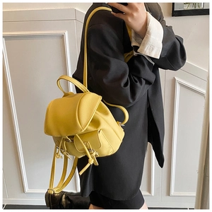 Close-up of yellow PU leather mini backpack showing litchi texture and drawstring detail