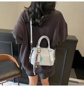 Detail view of the back of a light gray Boston bag with embossed letters and ornaments