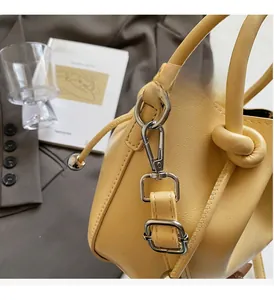 Detailansicht der gelben Leder-Eimertasche mit silbernen Metallhaken und D-Ringen