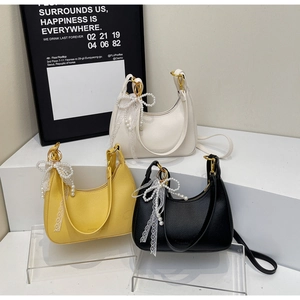 Trois sacs hobo en cuir blanc, jaune et noir avec breloques perles et détails en dentelle