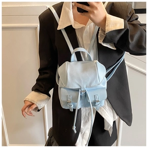 Close-up of light blue pebble leather mini backpack with flap and buckle pockets