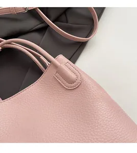 Close-up of pink bucket bag with litchi grain leather, smooth edges and fine stitching