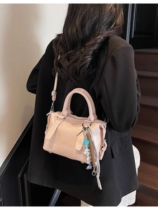 Minimalist light pink PU leather pillow bag with CHIC embossing and a decorative charm