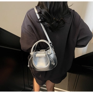 Silberne Metallic-Beuteltasche als Umhängetasche getragen von einem Modell im Innenraum