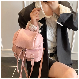 Detail of light pink lychee texture leather mini backpack with dual front pockets