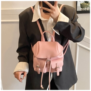 Pink mini backpack in pebble leather shown being worn as a crossbody bag