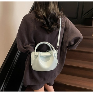 Detailansicht der minzgrünen Faltenhandtasche mit Metallperlen und schmalem Schultergurt