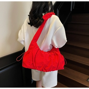 Close-up of red nylon tote bag with drawstring pleated detail and large capacity