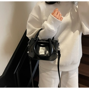 Modische schwarze Lackleder-Beuteltasche mit Glanzeffekt und silbernen Ringgriffen