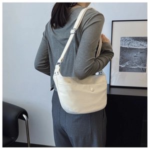 Detail of white dumpling shoulder bag with lychee texture and adjustable strap