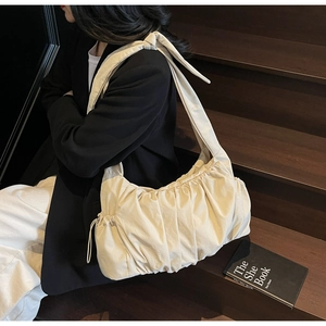 Detail of off-white pleated nylon tote bag with large decorative shoulder strap knot
