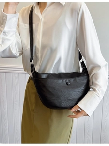 Fashionable black faux leather crescent crossbody bag with adjustable strap and silver hardware