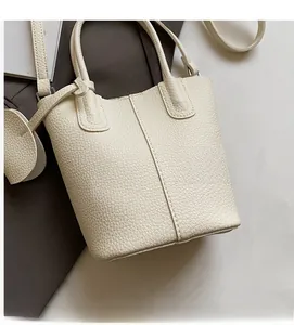 Dettaglio della borsa a secchiello in pelle martellata bianco crema con manici