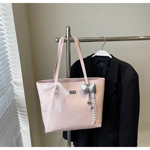 Detailed shot of pink PU tote bag with lace bow decoration and metallic butterfly pendant