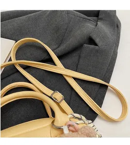 Detail of adjustable leather strap and litchi grain texture on yellow bowling bag
