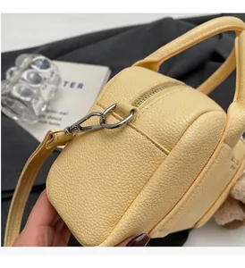 Close-up of pebble-grain leather texture and premium silver hardware on yellow handbag