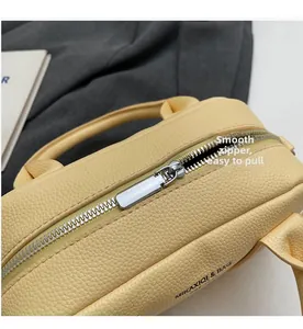 Close-up of smooth metal zipper and pebbled leather texture on yellow bowling bag
