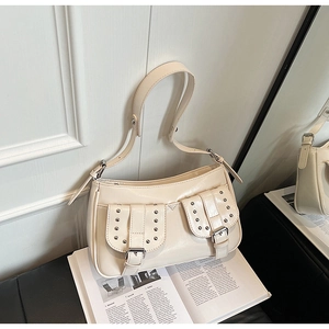 Detail of cream glossy leather underarm bag with silver rivet buckles and dual front pockets