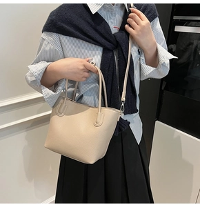 Beige lychee pattern leather bucket bag with top handles and slender shoulder strap