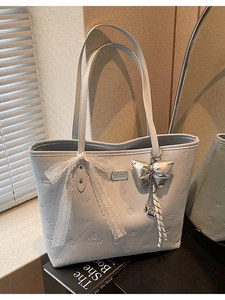 Light gray large tote bag with embossed bows and hearts featuring silver butterfly pendant