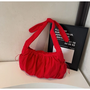 Detail of red nylon tote bag featuring ruffled texture and a large decorative bow