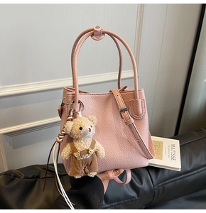 Pink lychee texture bucket bag with detachable strap and cute plush bear charm detail
