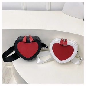 Detail of heart-shaped crossbody bags featuring contrast stitching and wide woven straps