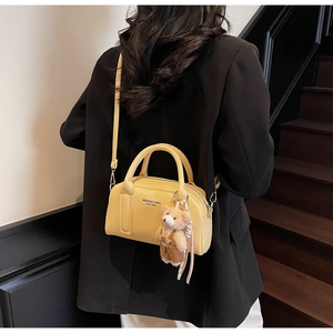 Detail of yellow lychee pattern bowling bag with bear charm and adjustable strap