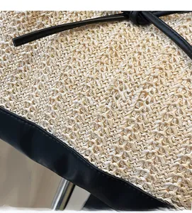Detailed macro view of woven straw texture with elegant black leather trimming for tote bags