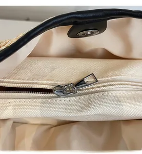 Detail view of woven tote bag with a smooth metal zipper and magnetic snap closure