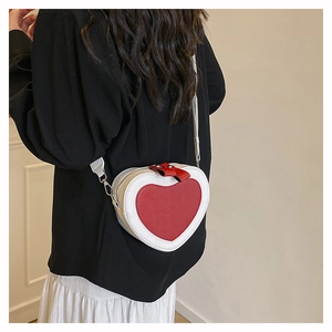 Detail view of heart-shaped crossbody bag with red and white leather patchwork design
