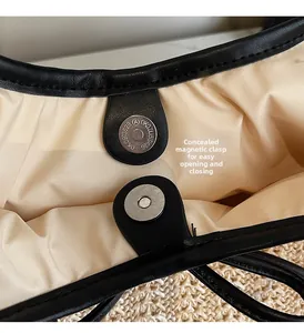 Detail of hidden magnetic buckle and fine stitching on a woven striped tote bag