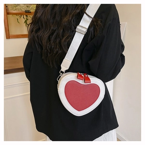 Detail shot of heart-shaped crossbody bag in red and white with adjustable strap
