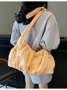 Large peach nylon pleated tote bag with adjustable drawstrings and wide shoulder strap