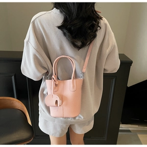 Borsa a secchiello rosa con ciondolo a elefante indossata da una modella per la taglia
