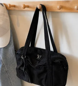 Dettaglio del manico in denim robusto e della zip metallica sulla borsa nera casual