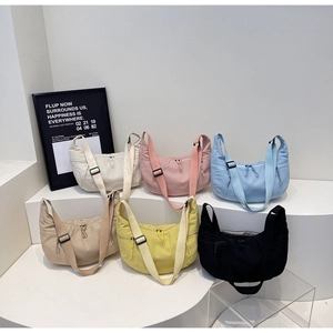 Macro display of nylon crescent bags in six pastel colors with adjustable wide shoulder straps