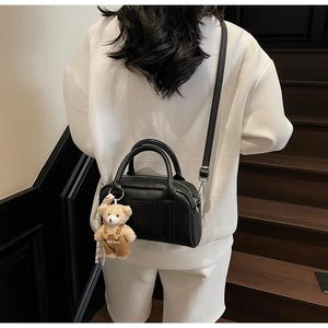 Black pebbled leather bowling bag with metallic zipper and cute teddy bear pendant charm