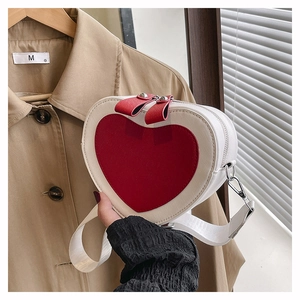 Detail of heart-shaped crossbody bag with white cross-grain leather and red heart contrast