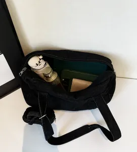 Dettaglio interno di una borsa a tracolla in denim nero con grande capacità per oggetti