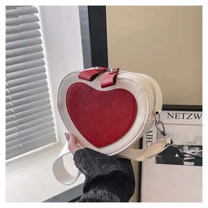 Detail of a heart-shaped crossbody bag featuring cream PU leather and red heart motif