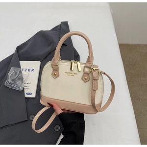 Detailed close-up of the dual-zip shell bag showing the creamy white leather texture