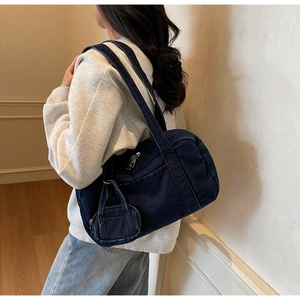Dettaglio borsa a spalla in denim blu scuro con mini borsellino coordinato